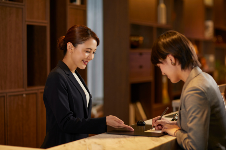Guest checking in at reception with friendly host, showing smooth arrival experience in a clean and welcoming space
