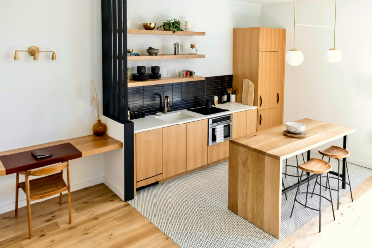 Modern Airbnb kitchen with functional layout, wooden interiors, open shelving, and dining workspace